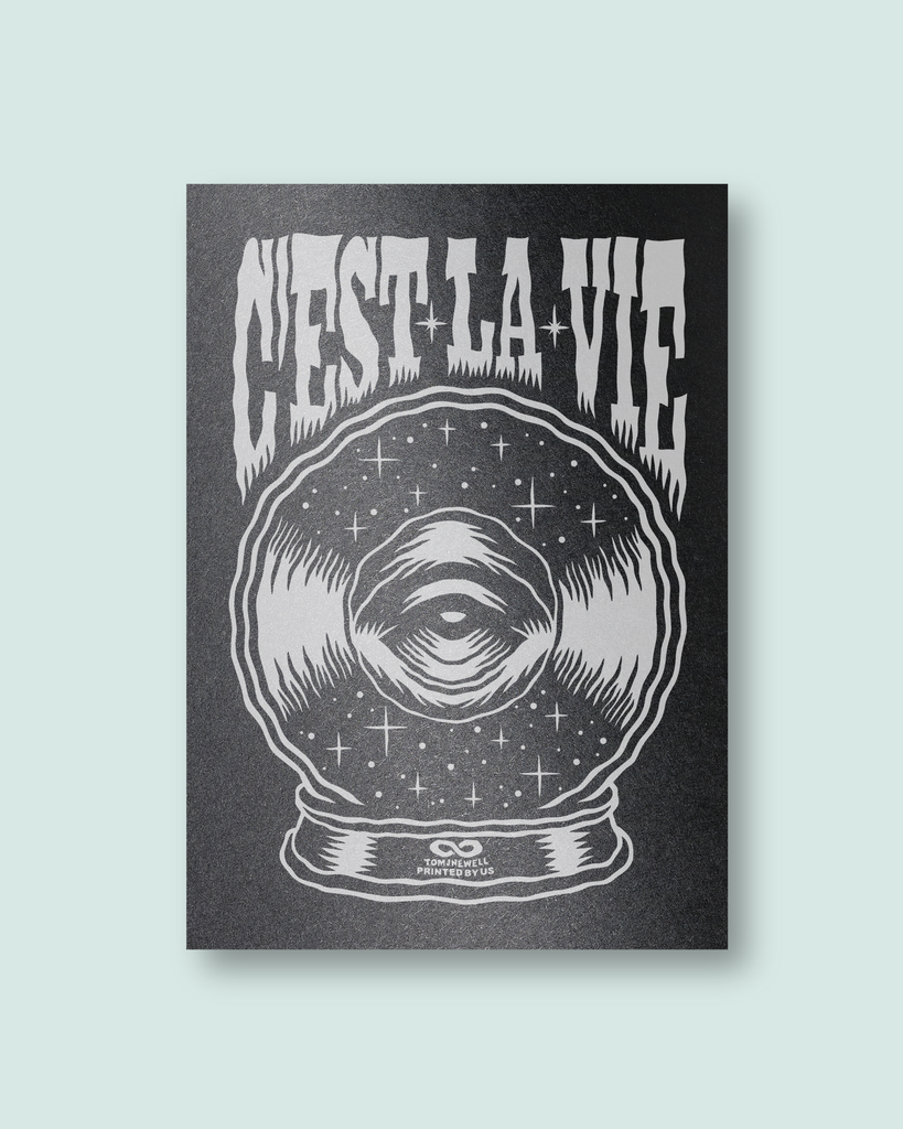 Screen print with 'C'est La Vie' text and eye in a crystal ball design on black paper